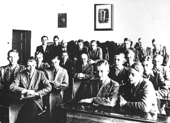 Auf einem schwarz-weiß-Foto sitzen die mit Anzug gekleideten etwa 20 Jungen der 7d an ihren Unterrichtstischen. Ganz hinten im Bild sitzen Lehrer.