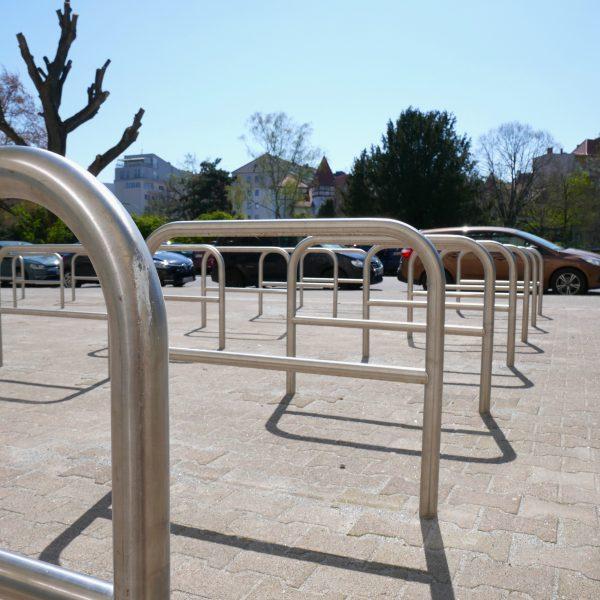 Viele moderne Bügelfahrradständer auf neu gepflastertem Boden.