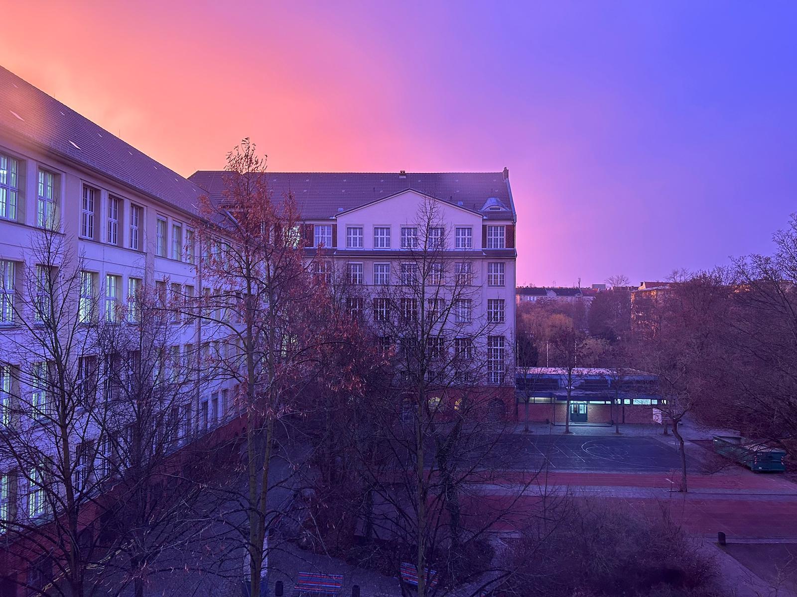 Friedrich-Ebert-Gymnasium bei Sonnenaufgang, vom Schulhof aus gesehen.